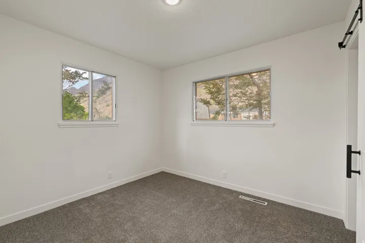 Spare room featuring dark colored carpet and a barn door