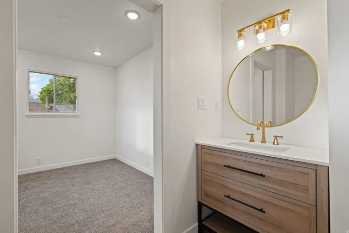 Bathroom with vanity, light carpet, and recessed lighting