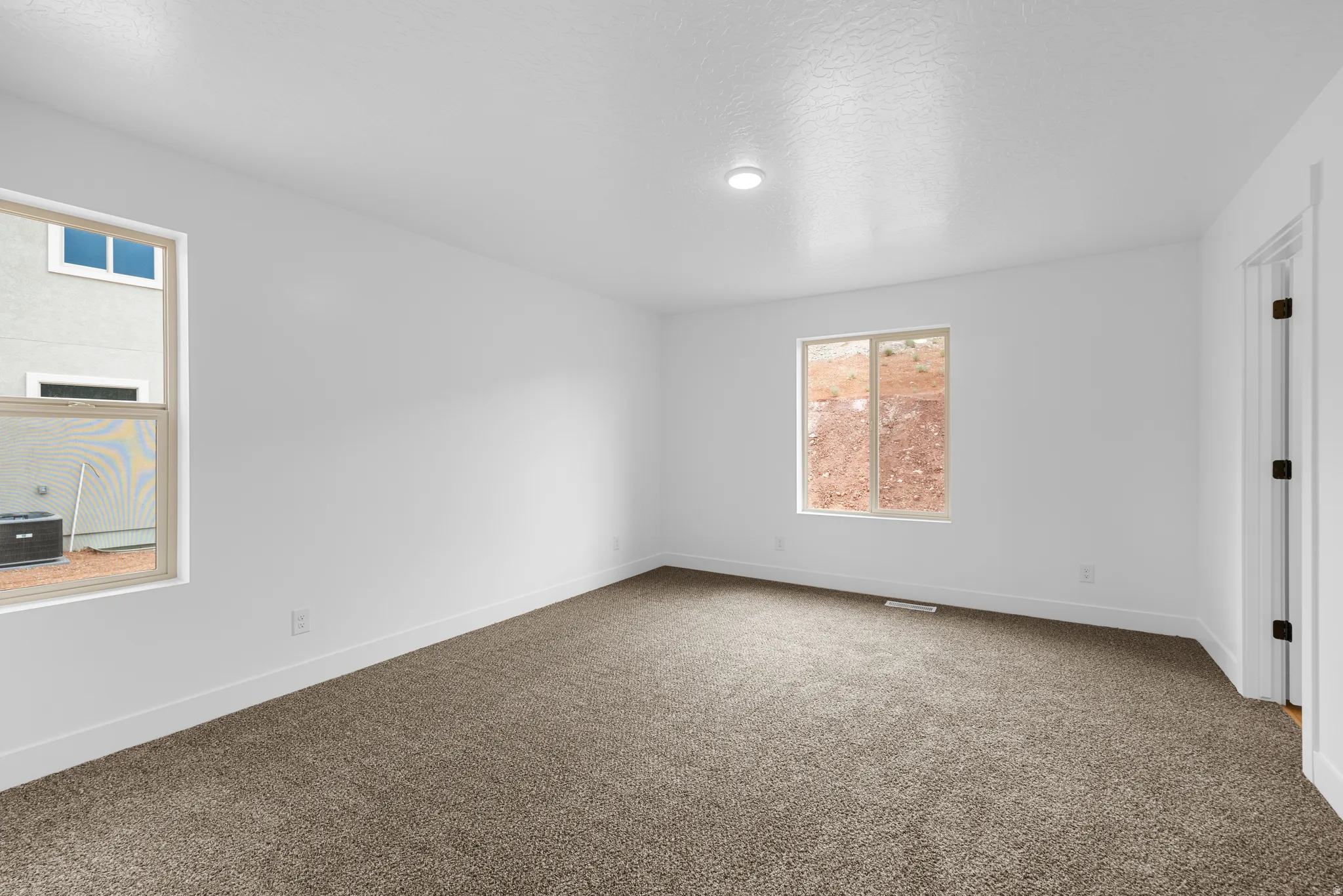 Spare room with baseboards and dark carpet