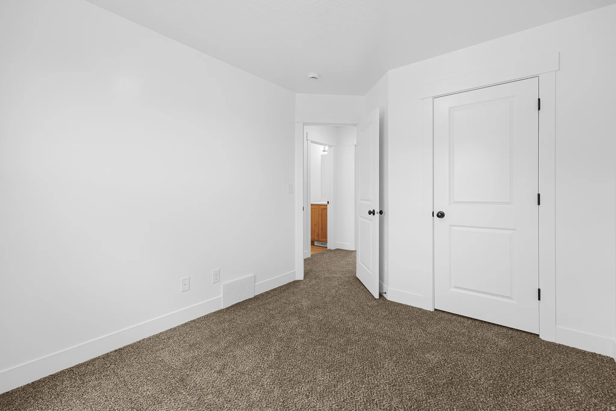 Unfurnished bedroom with dark carpet and a closet