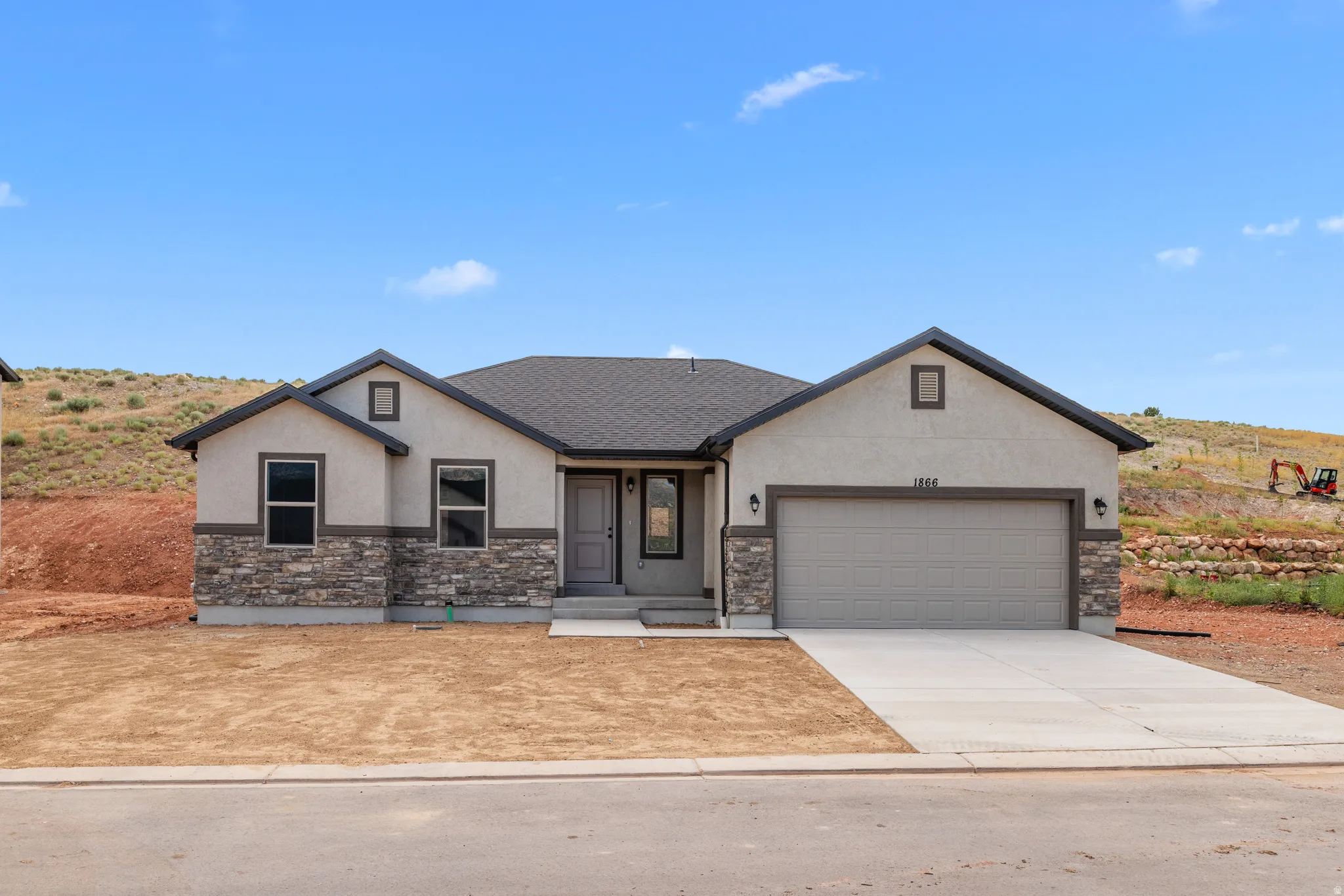 View of front of property with stucco siding, a garage, stone siding, driveway, and roof with shingles