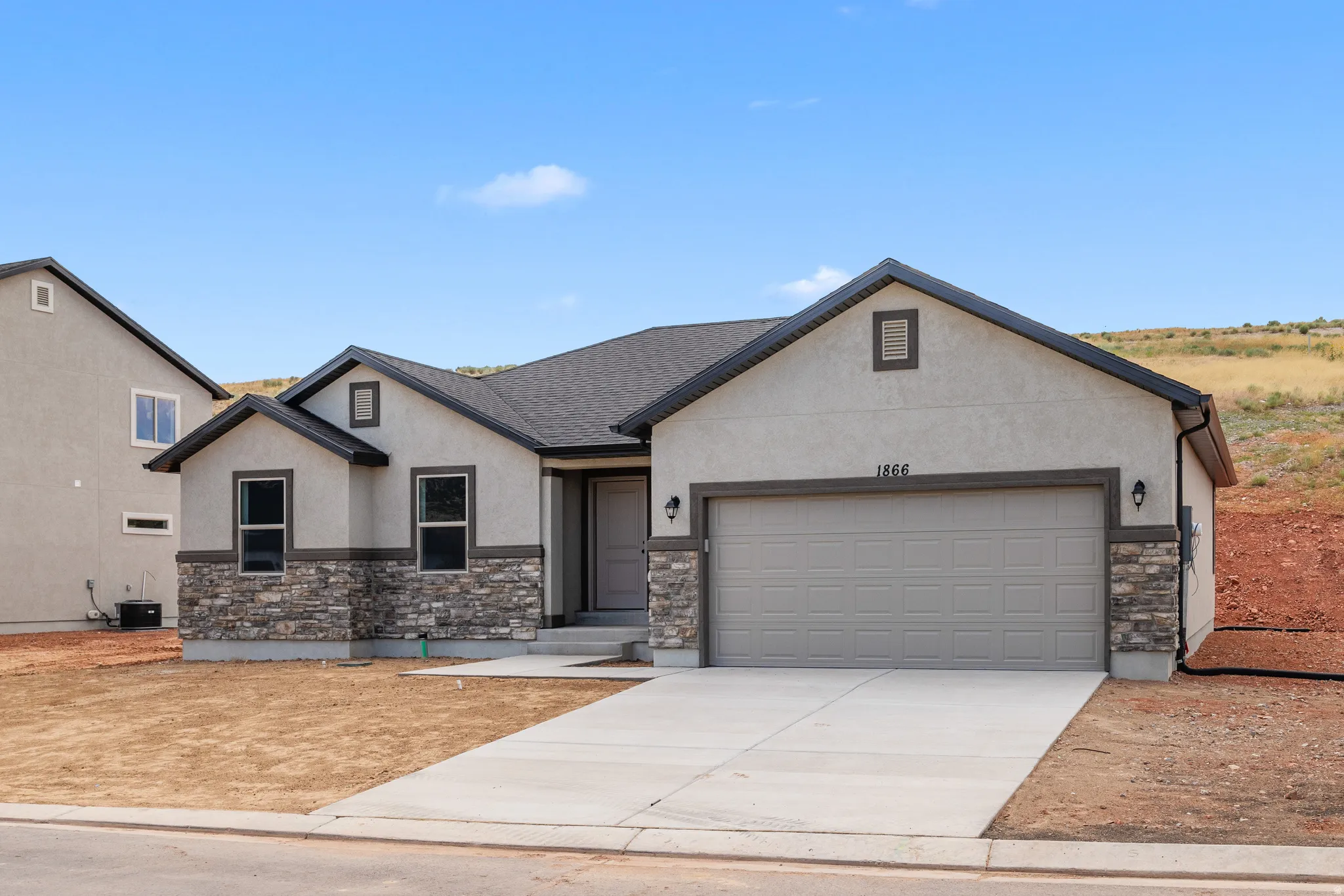 View of front of home featuring stone siding, stucco siding, driveway, an attached garage, and a shingled roof
