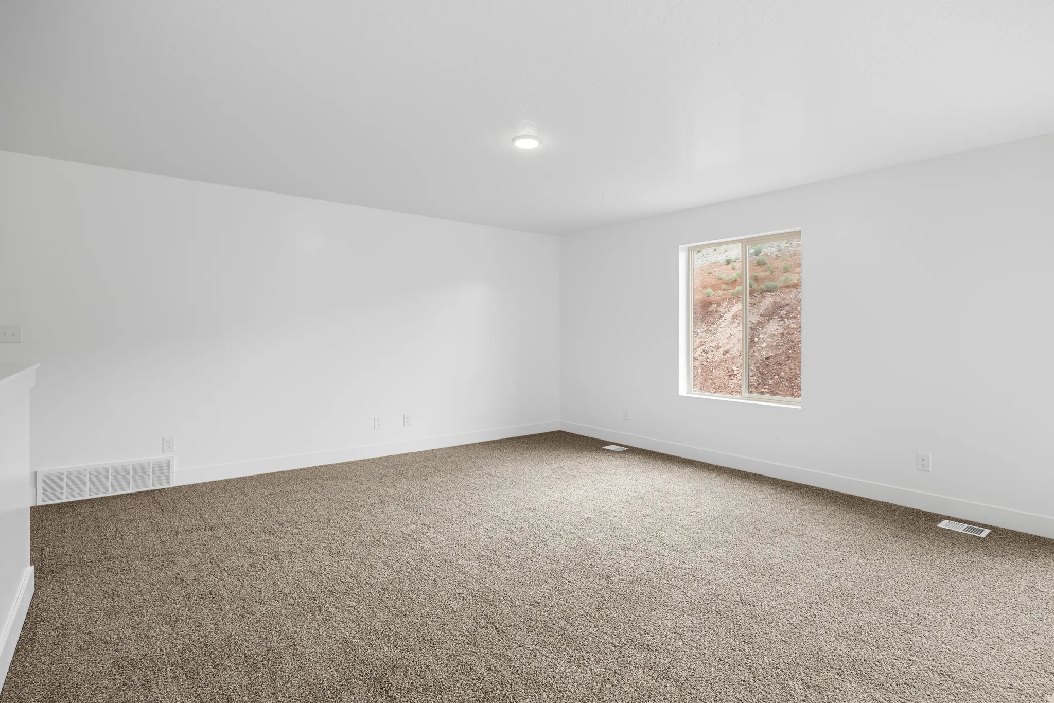 Carpeted spare room featuring baseboards