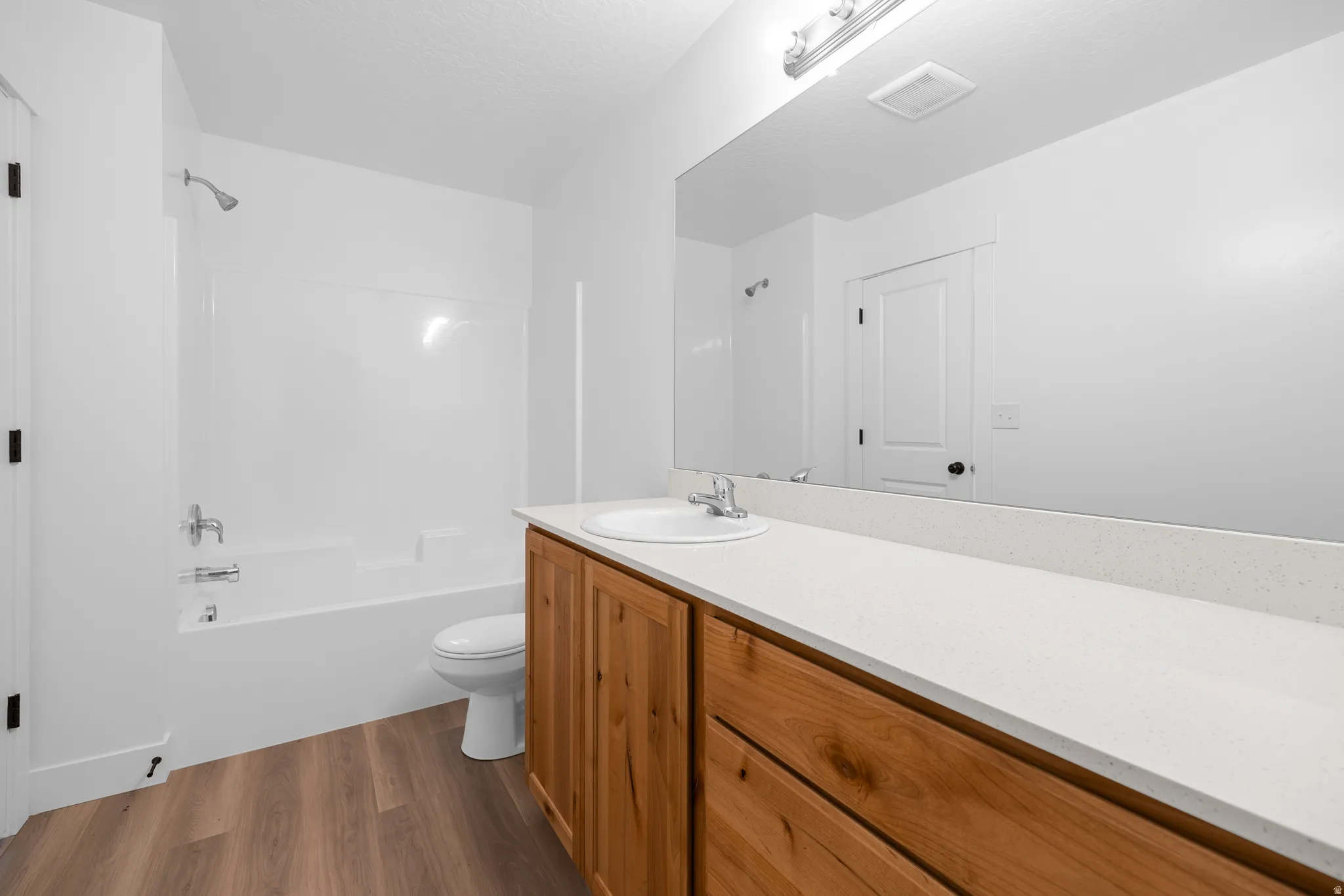 Full bath featuring vanity, dark wood-style flooring, bathtub / shower combination, and a textured ceiling