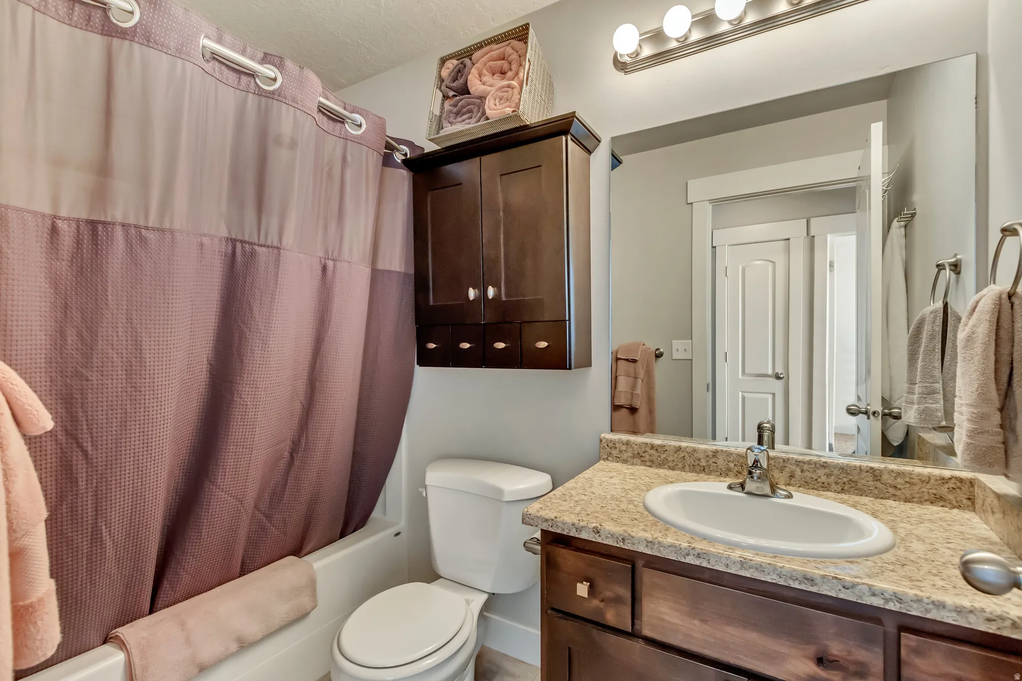 Bathroom with vanity and shower / bath combination with curtain