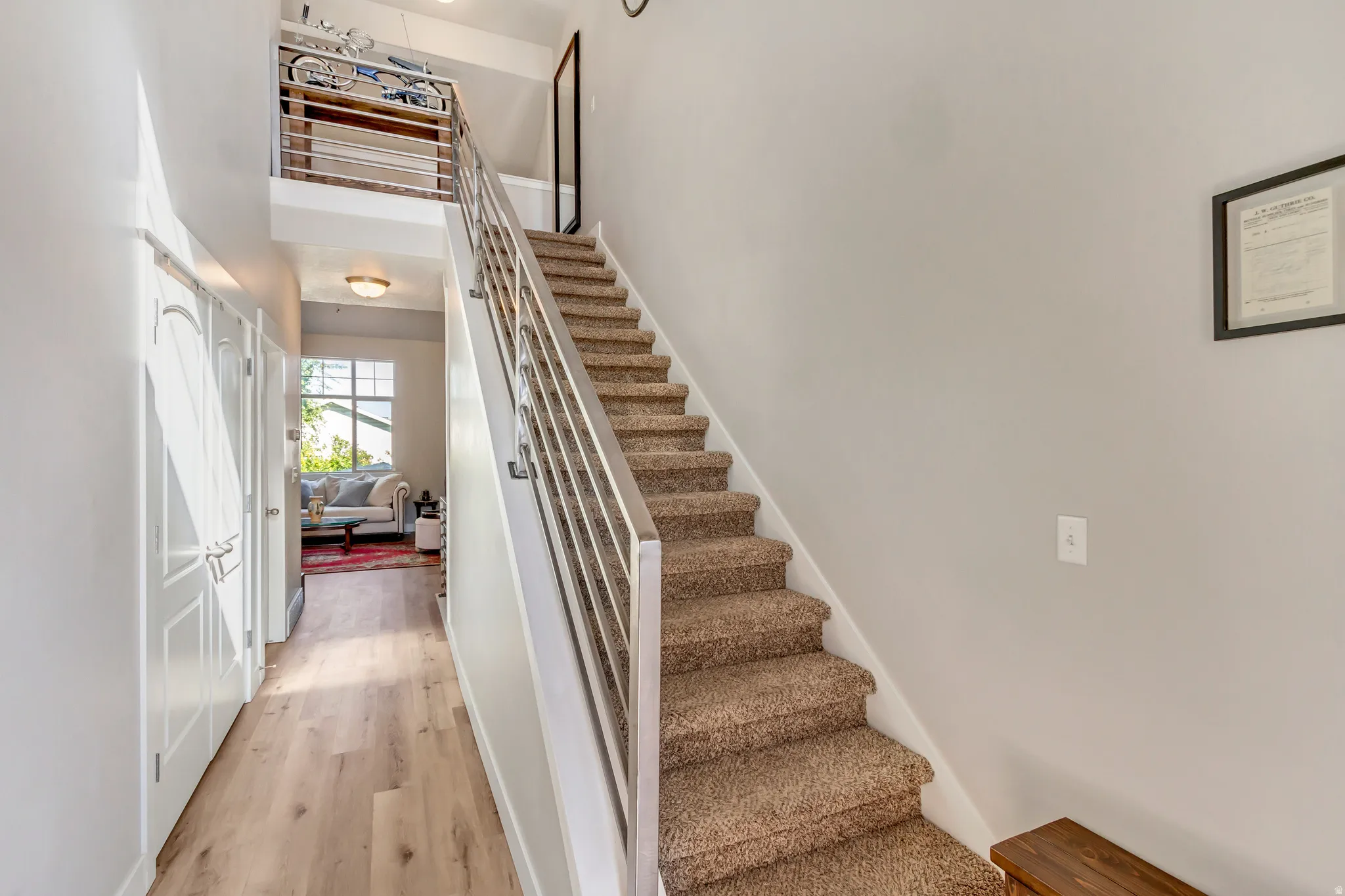 Stairway featuring wood finished floors and a high ceiling