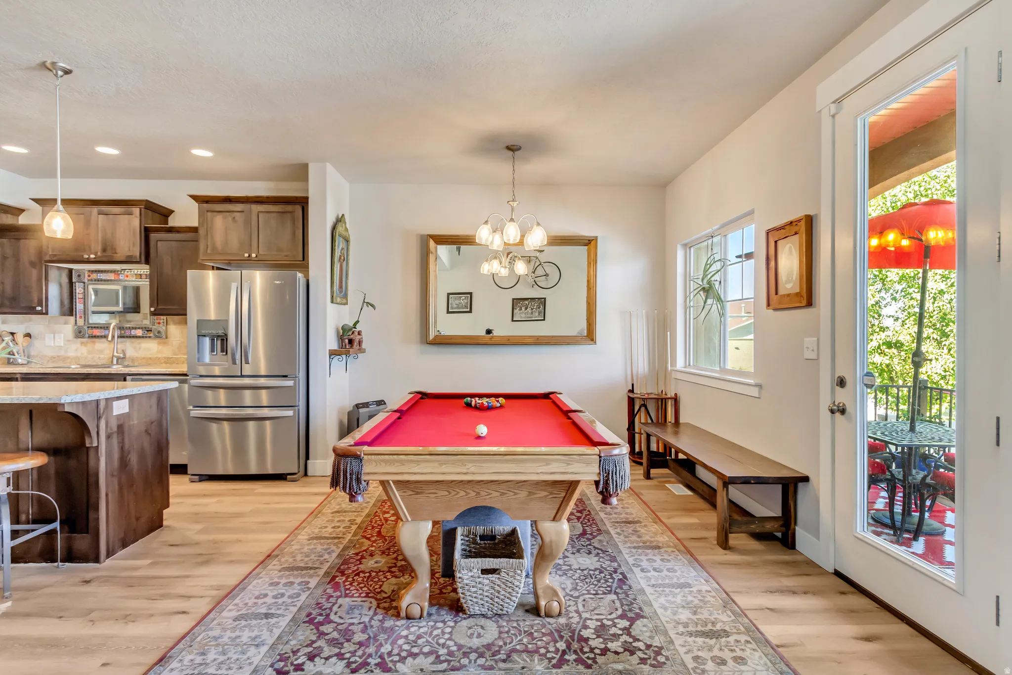 Rec room with light wood-style flooring, suspended lighting, and billiards table