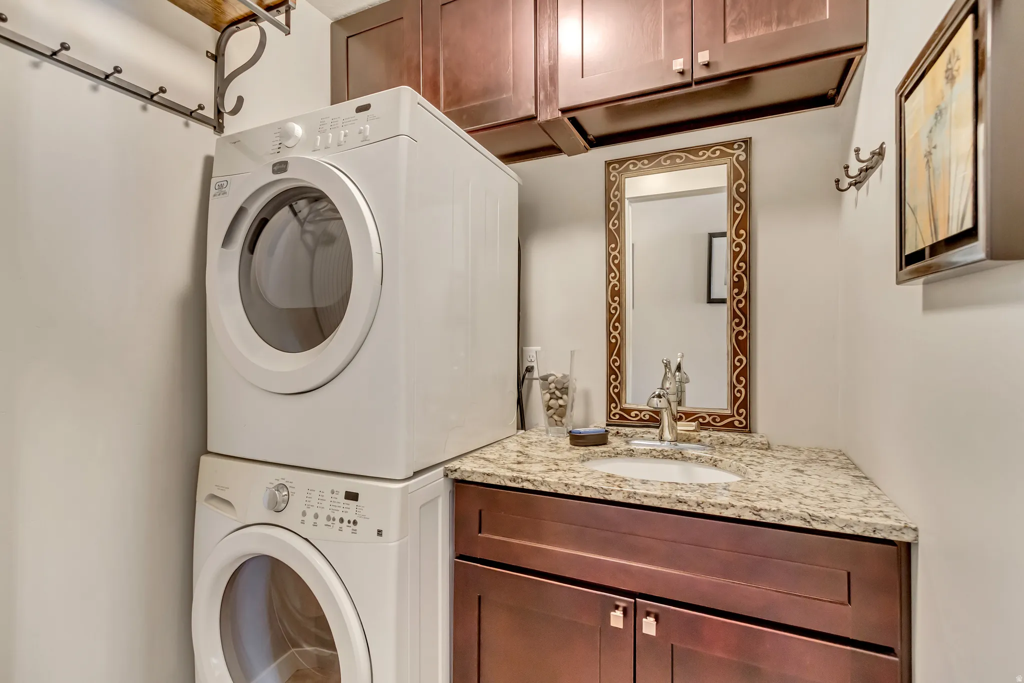 Laundry area featuring cabinet space and stacked washing machine and dryer