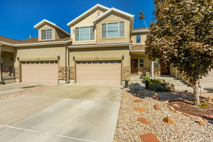 Craftsman inspired home featuring covered porch, concrete driveway, stone siding, an attached garage, and stucco siding