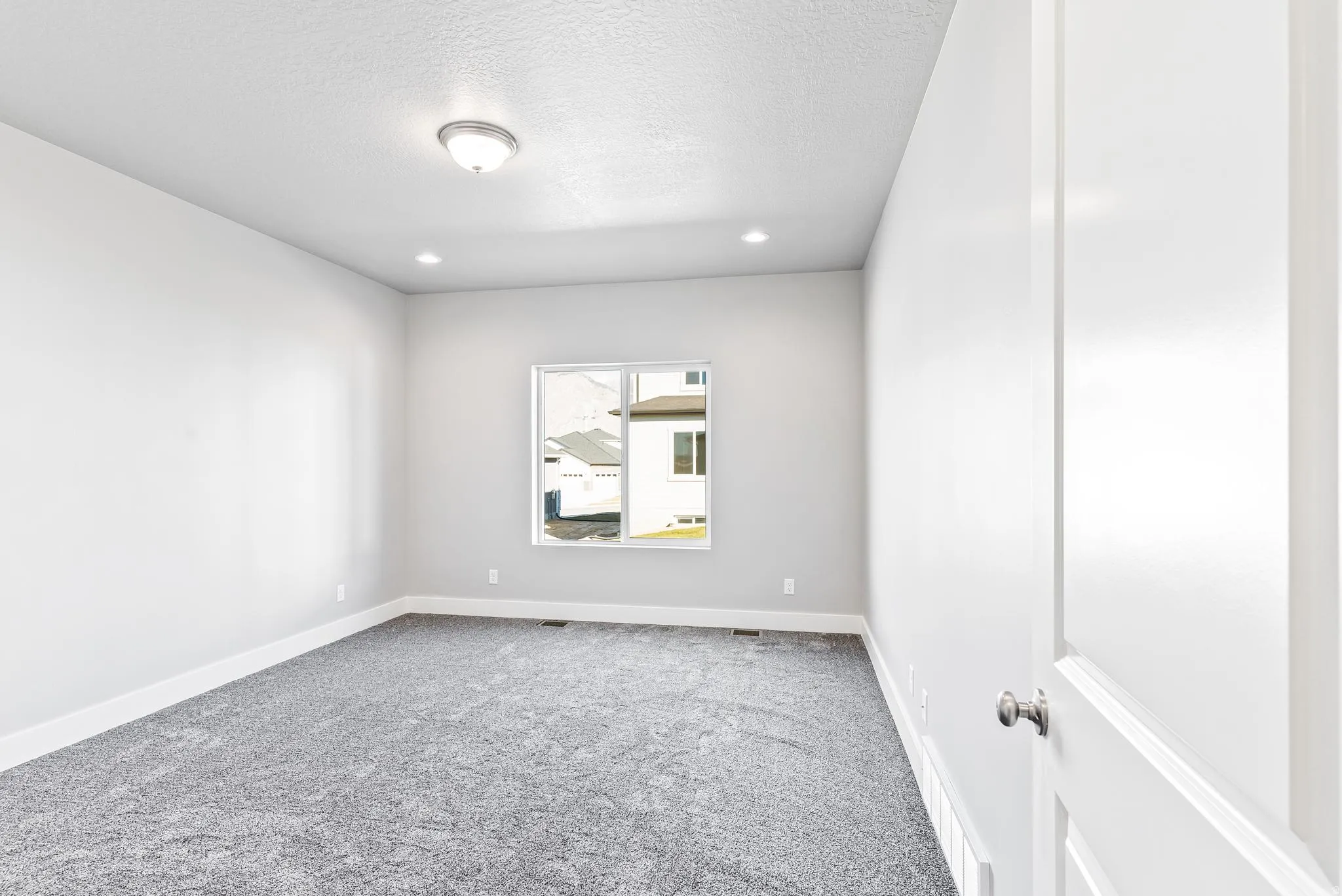 Spare room with carpet flooring and a textured ceiling