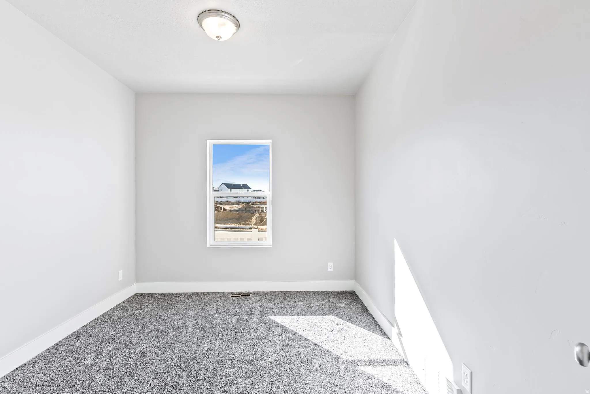 Carpeted empty room featuring baseboards