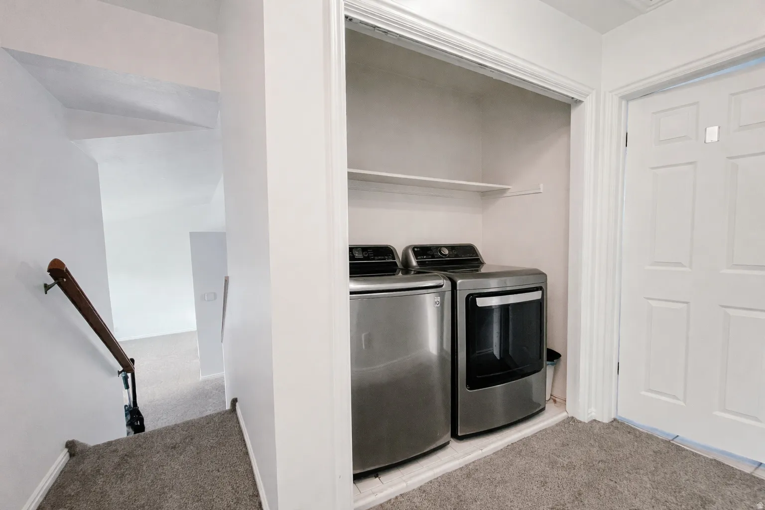 Laundry room with light carpet and washing machine and clothes dryer