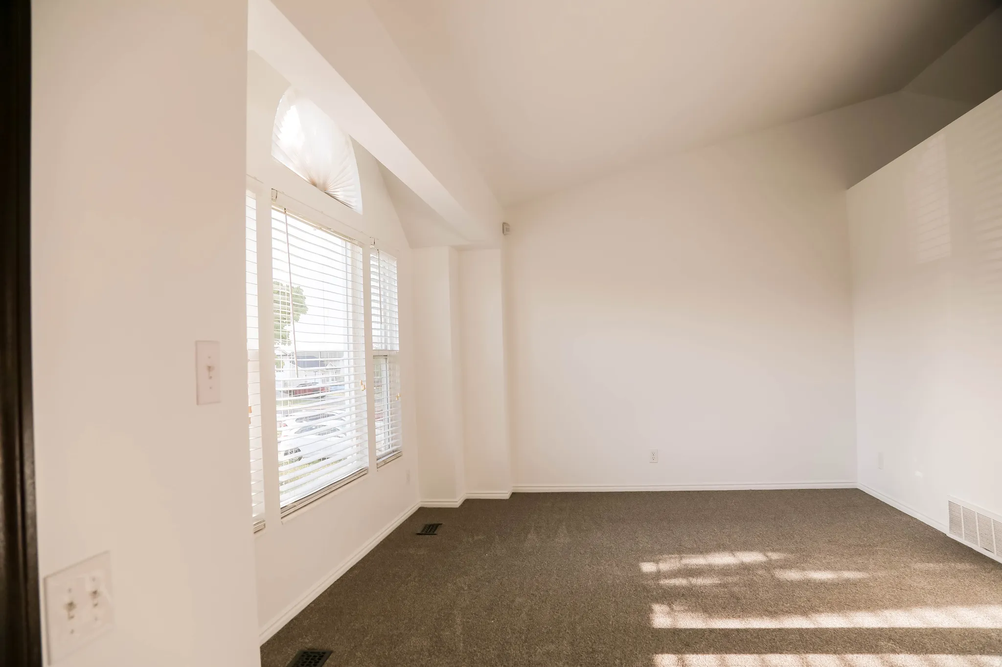 Spare room with lofted ceiling and dark colored carpet