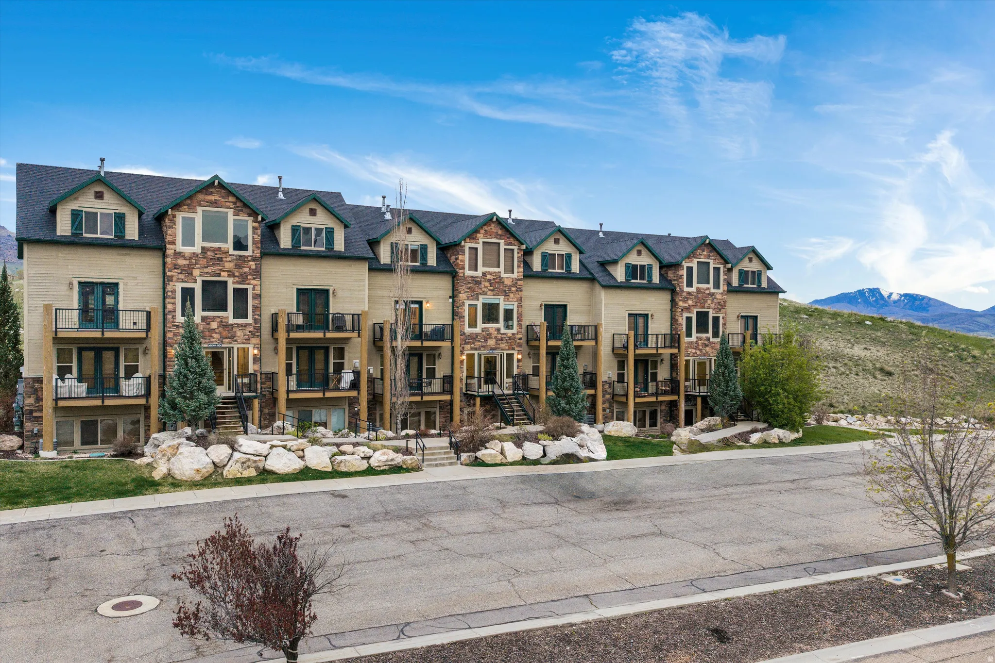View of front of house with stone siding and a mountain view