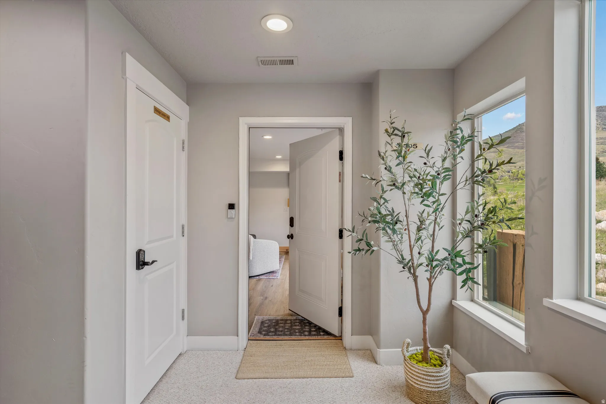 Hallway with light carpet and recessed lighting