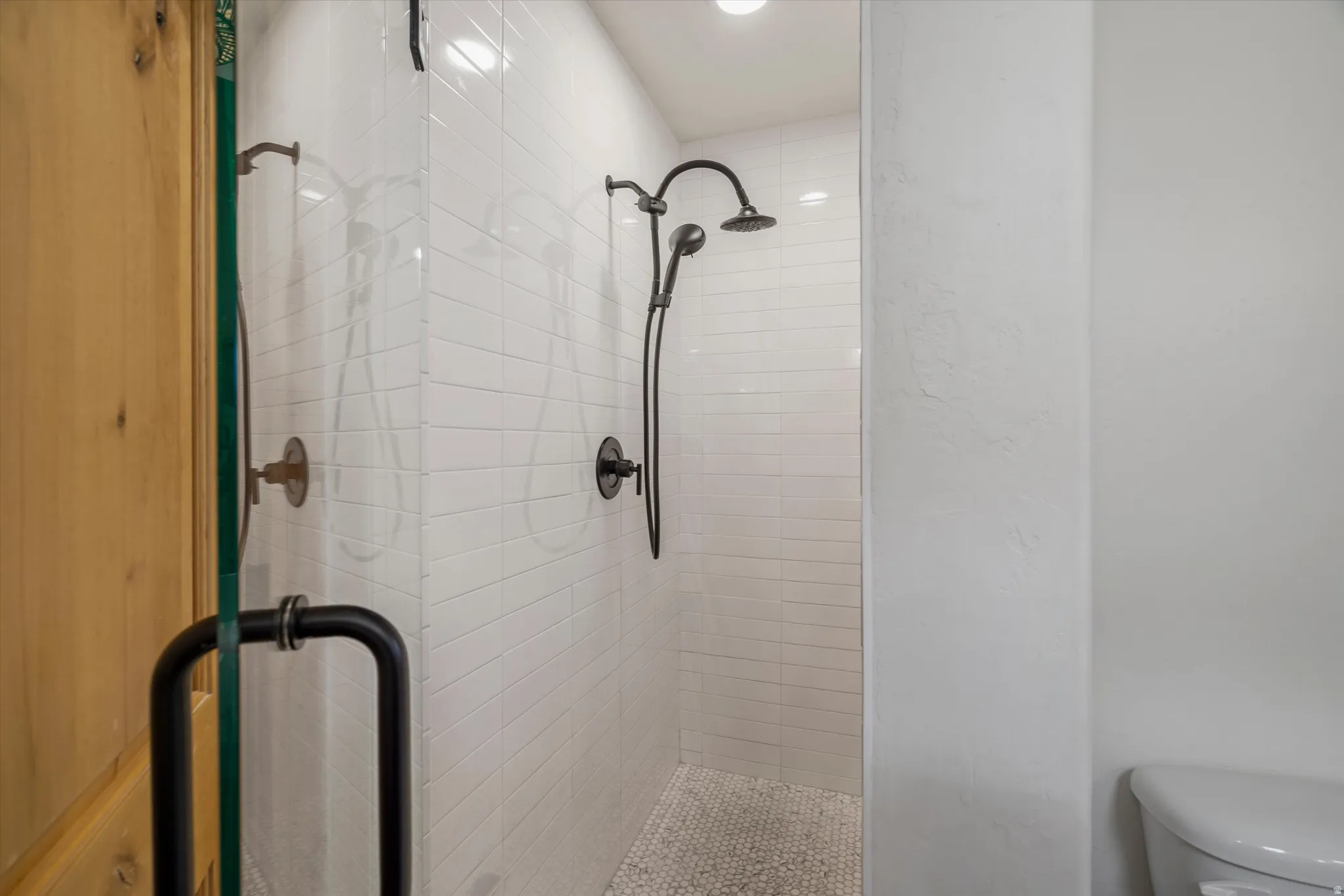 Full bathroom featuring a stall shower and toilet