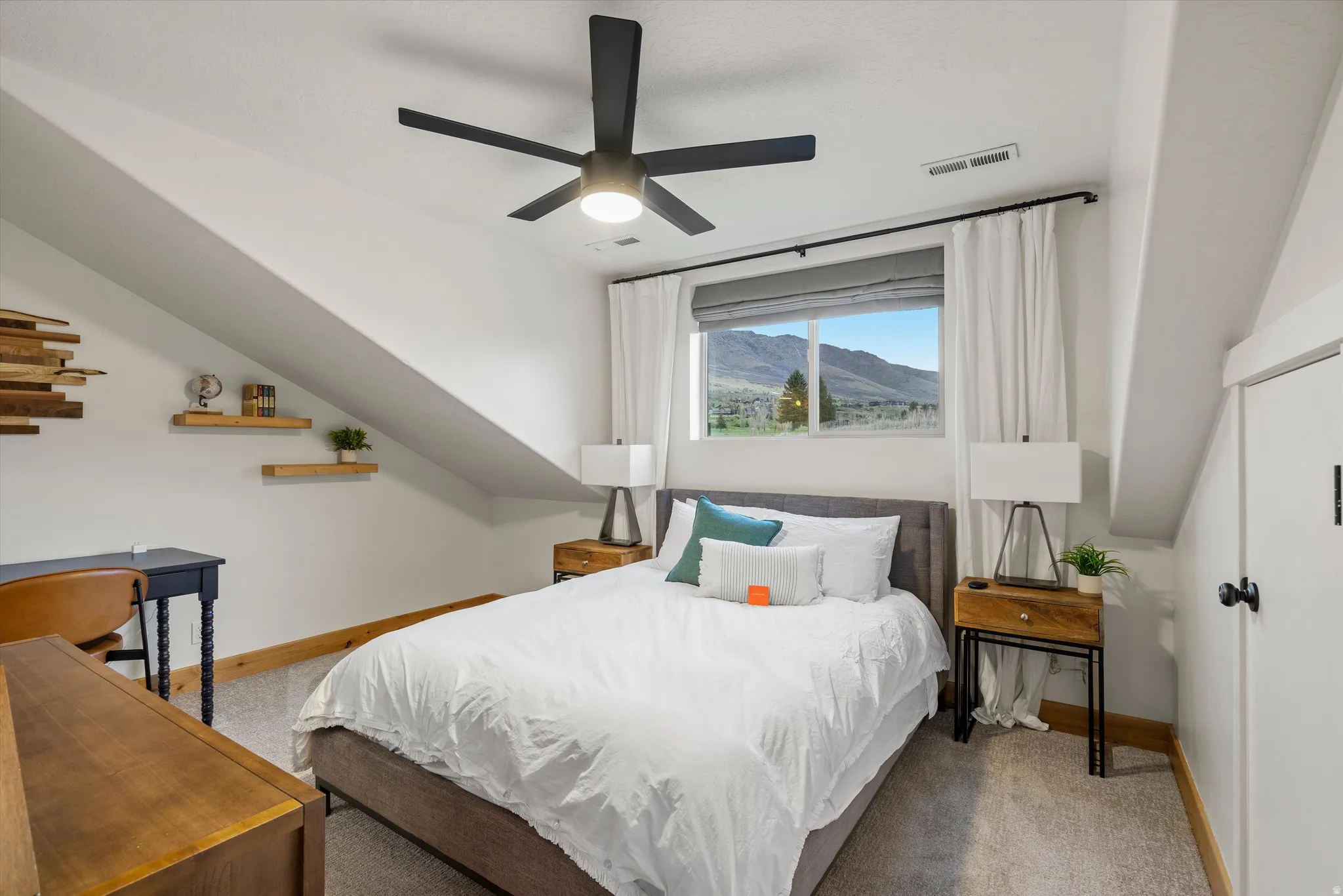 Bedroom featuring a mountain view, light carpet, and ceiling fan