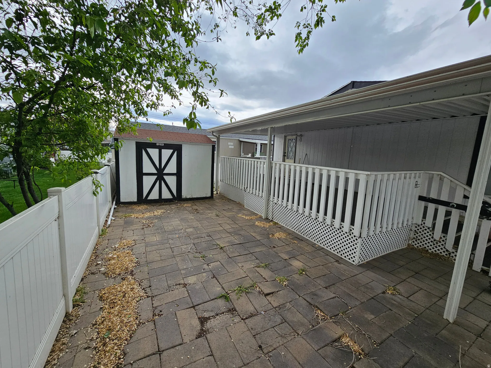 Fenced backyard with a storage unit, a patio, and a wooden deck