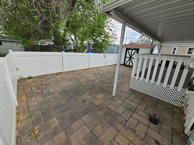 Fenced backyard featuring a patio area and a shed