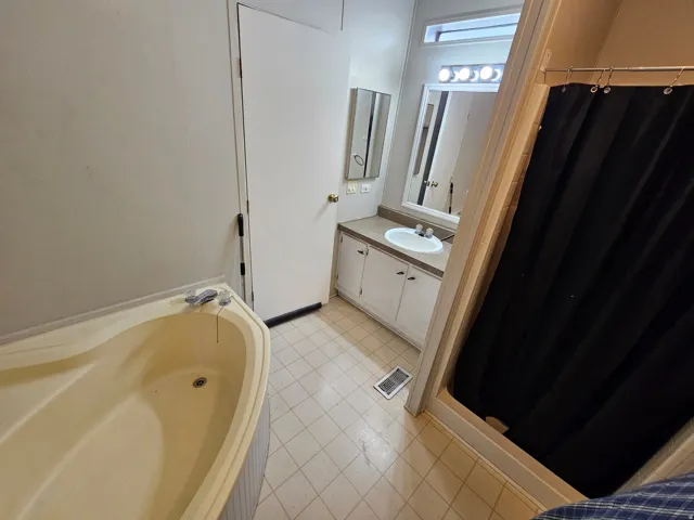 Full bathroom with vanity, a stall shower, and a bath