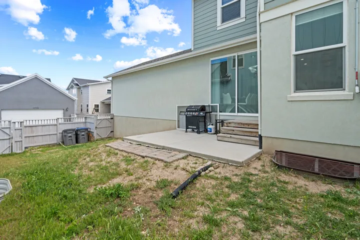 Fenced backyard with a gate, a patio area, and entry steps