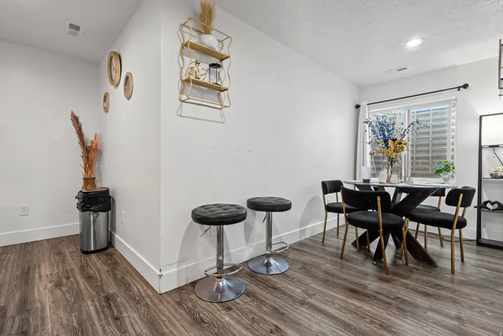 Dining room featuring dark wood-style floors, a textured ceiling, and recessed lighting