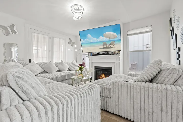 Bedroom with wood finished floors and a glass covered fireplace