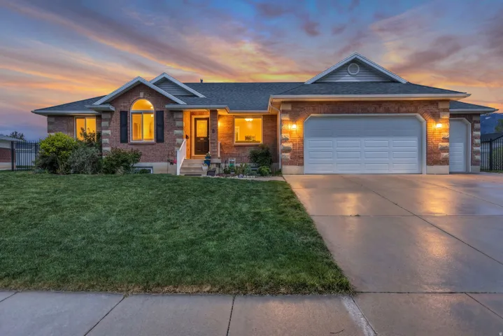 Single story home with an attached garage, driveway, brick siding, and a shingled roof