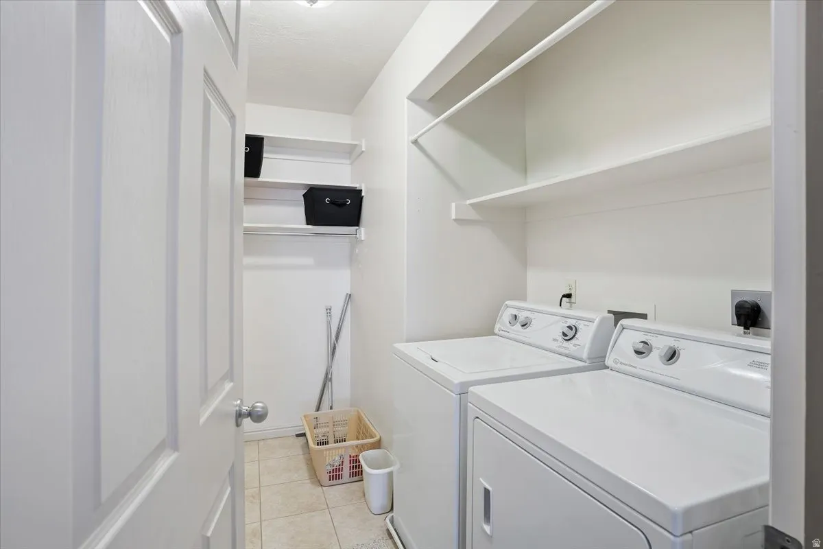 Laundry room featuring separate washer and dryer and light tile patterned floors