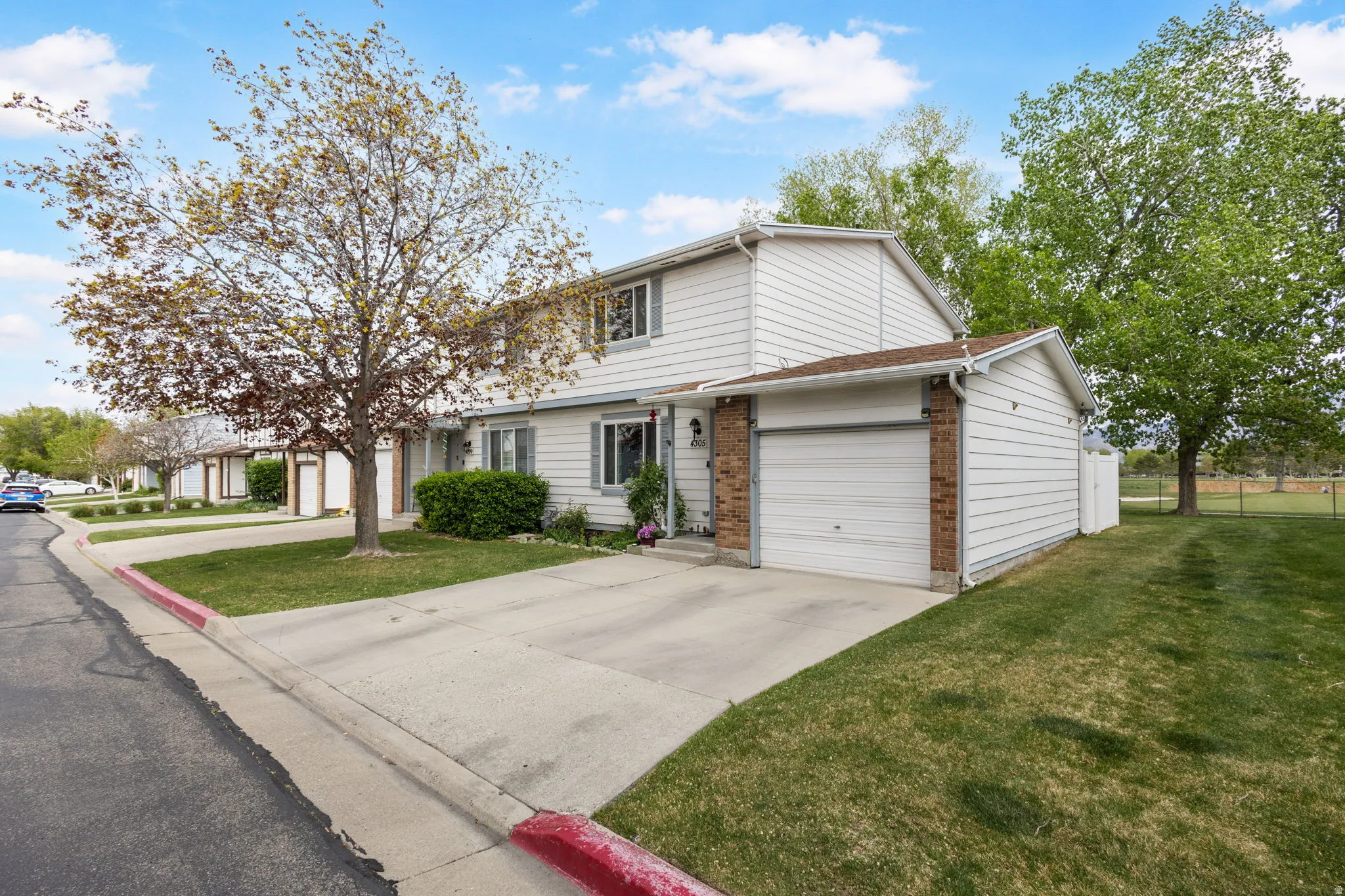 View of front of property with brick siding, concrete driveway, and a garage