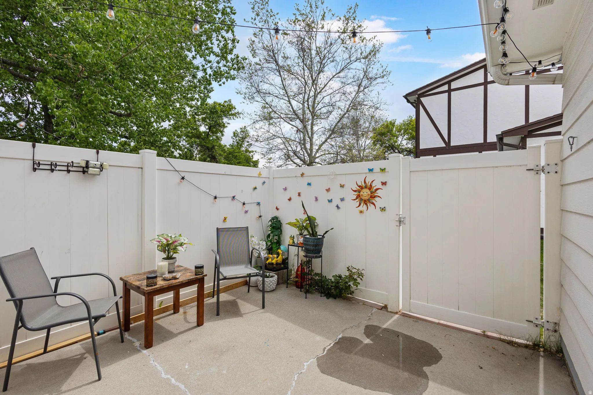 View of patio featuring a gate and a sunroom
