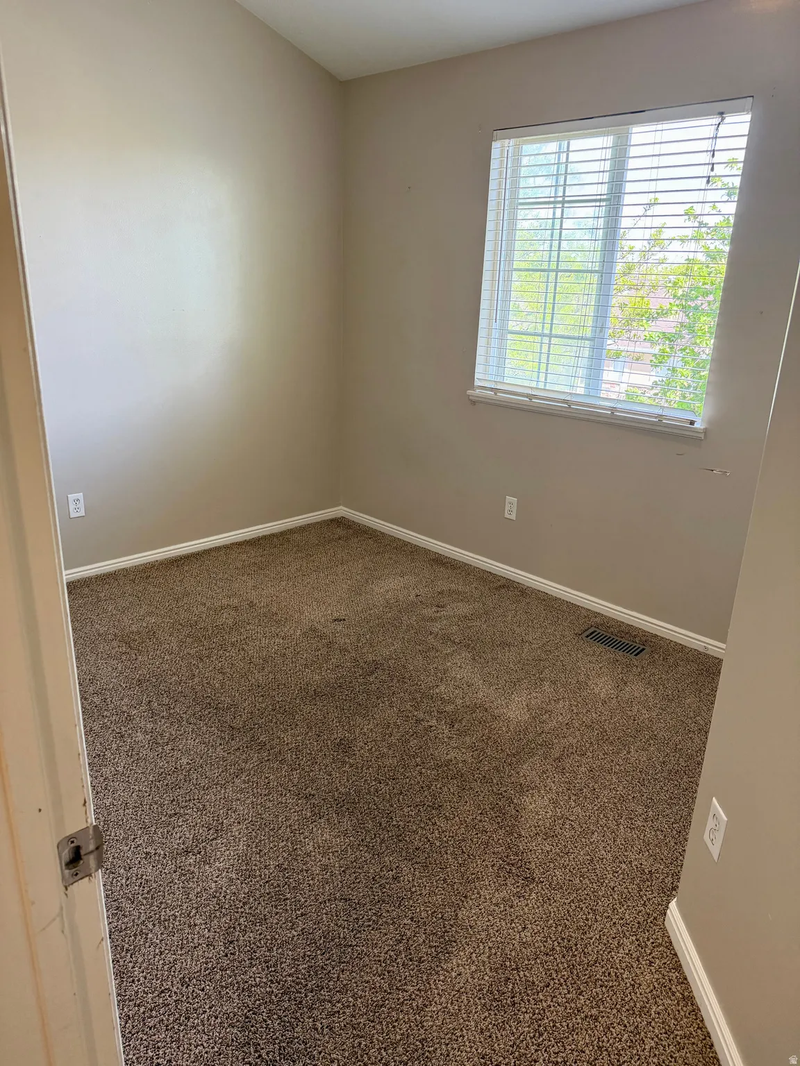 Unfurnished room with dark carpet and baseboards