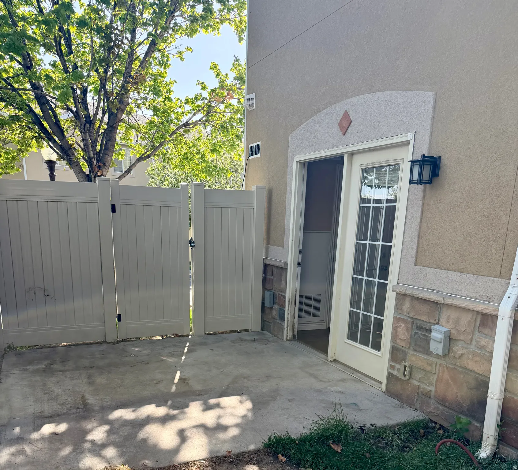 Property entrance featuring a gate, a patio area, and stucco siding