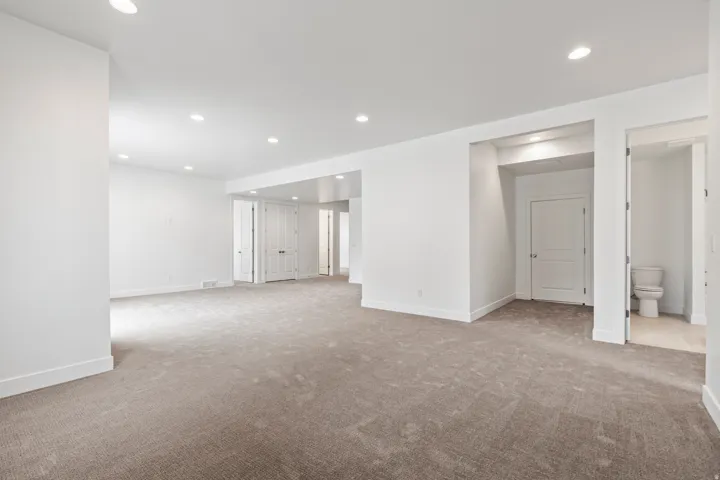 Carpeted spare room featuring recessed lighting and baseboards