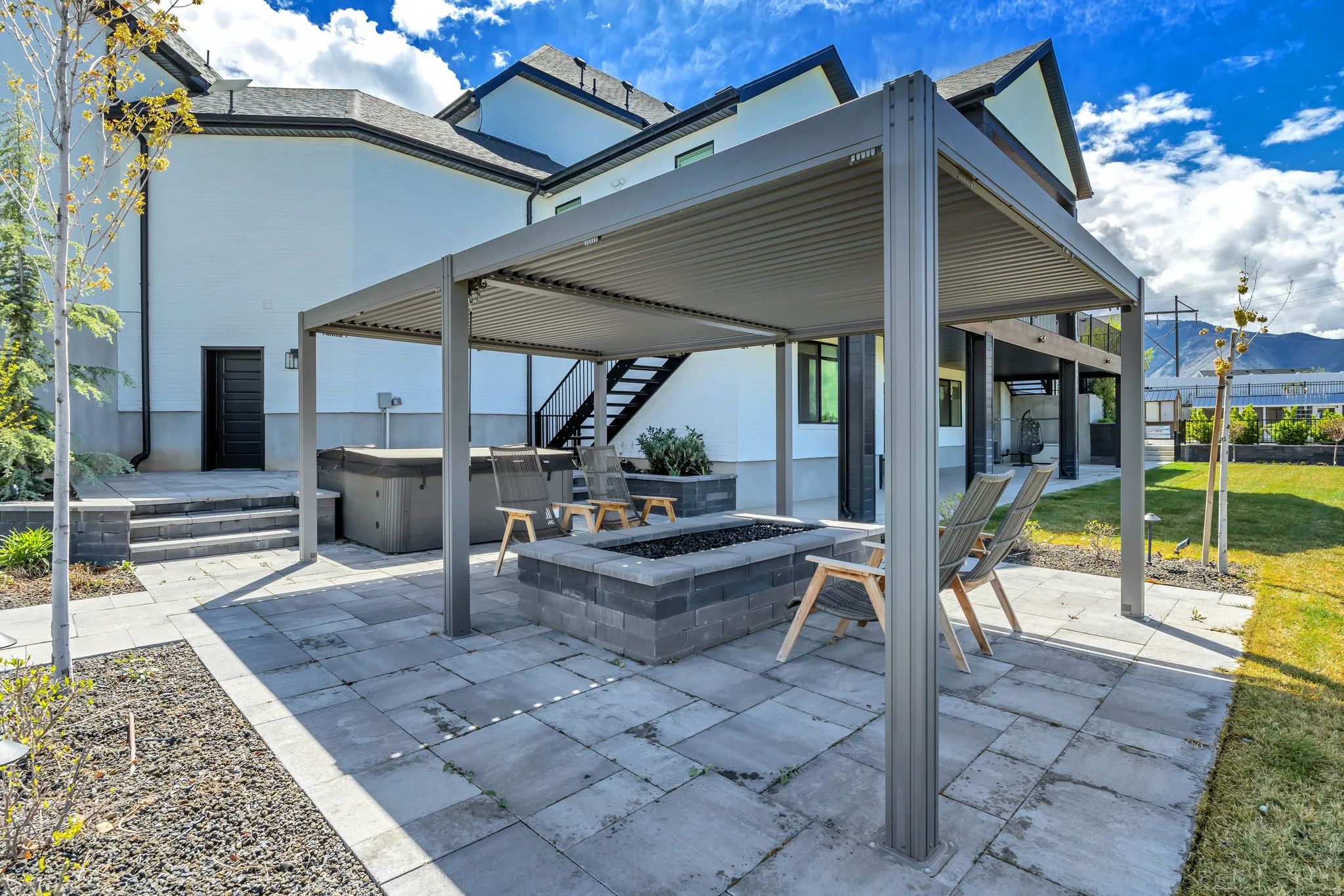View of patio / terrace featuring a hot tub, a fire pit, and a mountain view