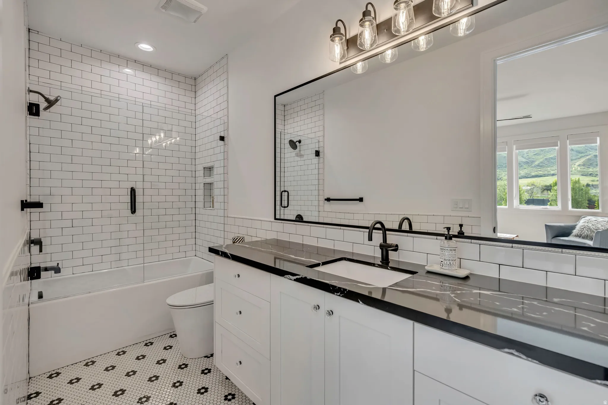 Full bath with vanity, light tile patterned floors, shower / bath combination with glass door, and tile walls