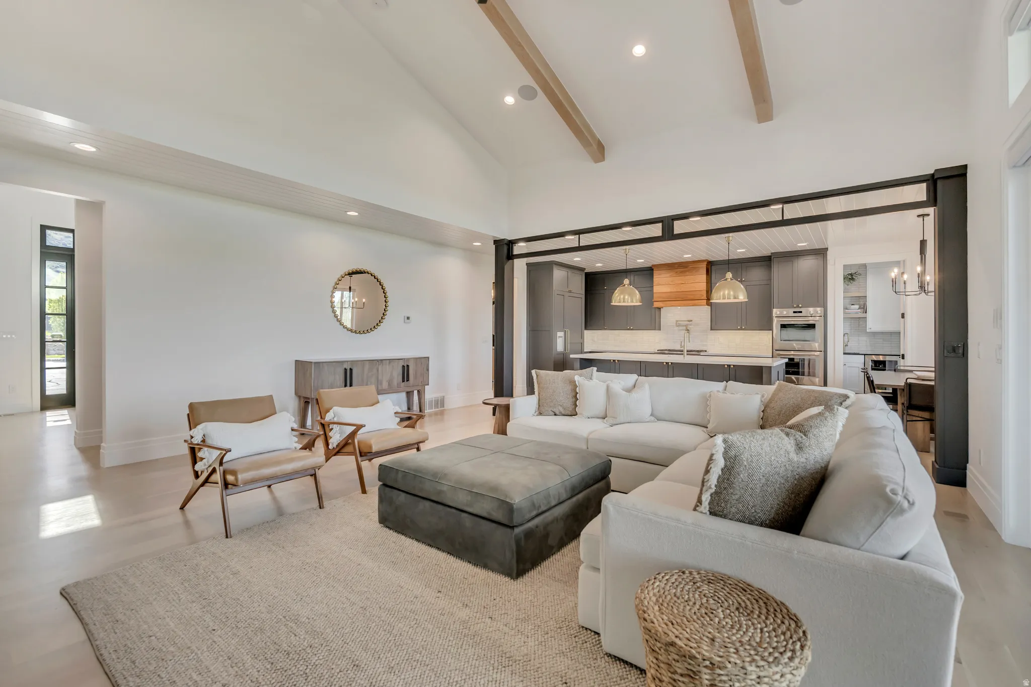 Living room with a chandelier, light wood-style flooring, and vaulted ceiling