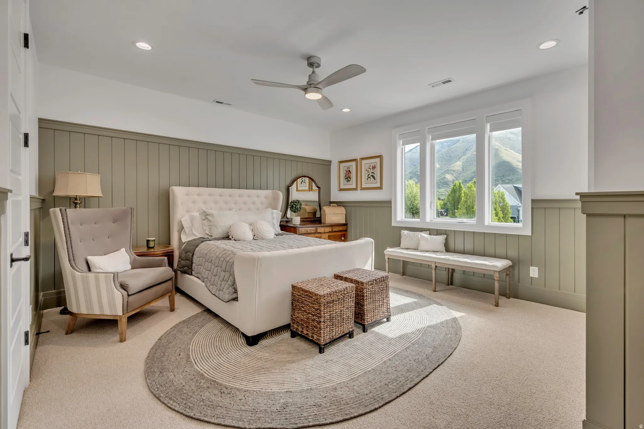 Carpeted bedroom featuring wainscoting, ceiling fan, recessed lighting, and a decorative wall