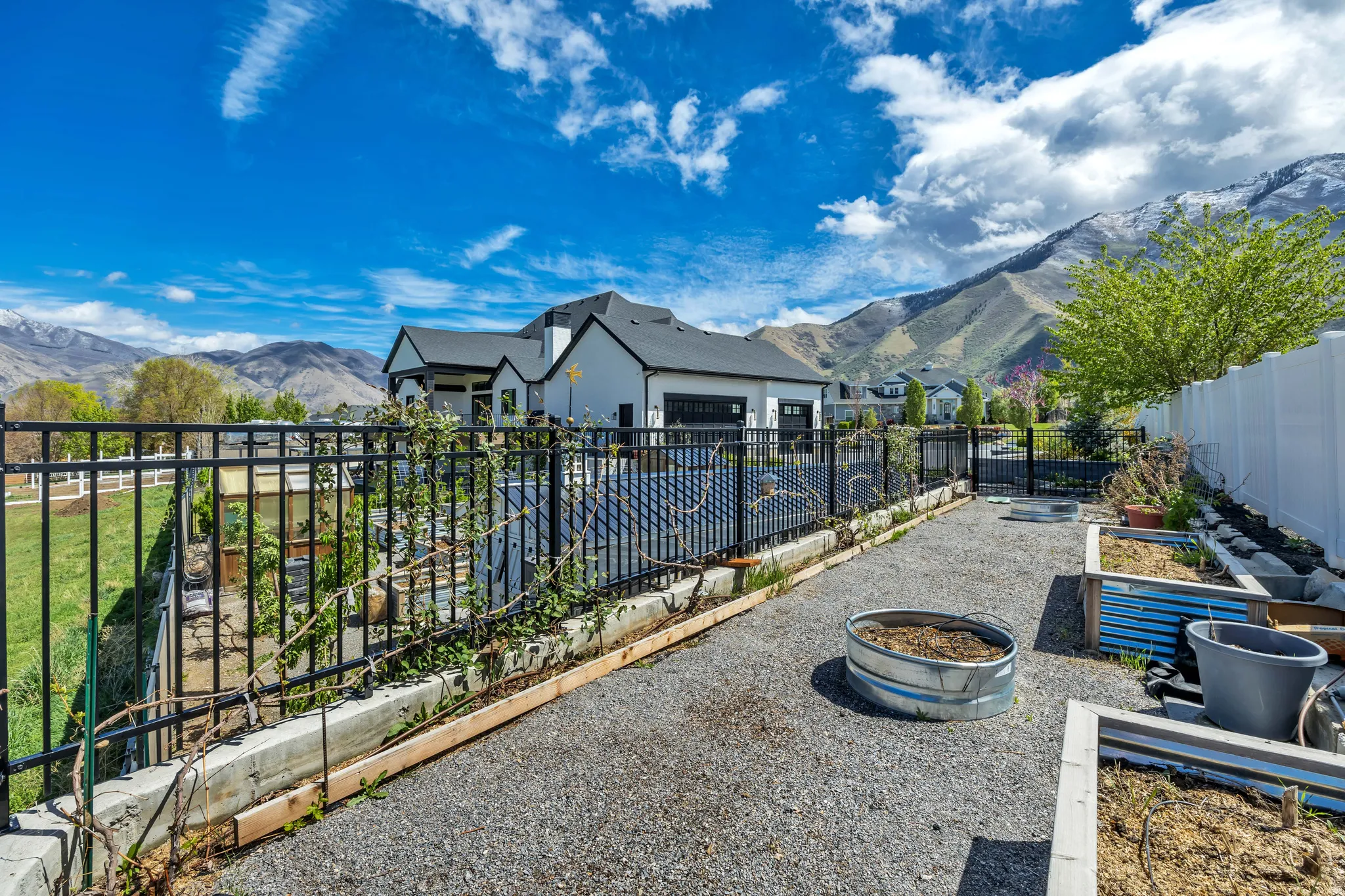 Fenced backyard featuring a mountain view, a garden, and a patio