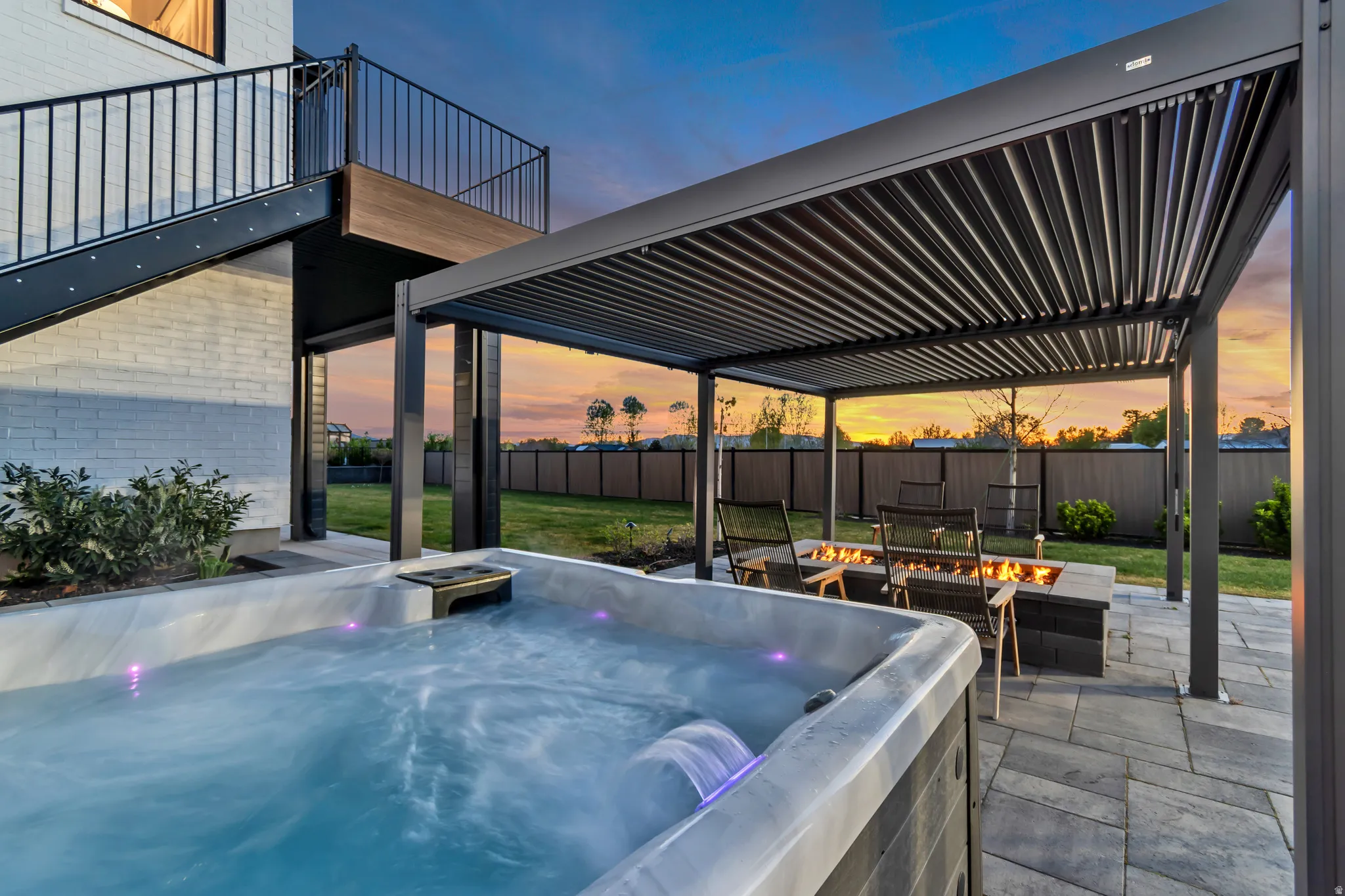 Patio terrace at dusk featuring a patio, a fire pit, a hot tub, and a pergola