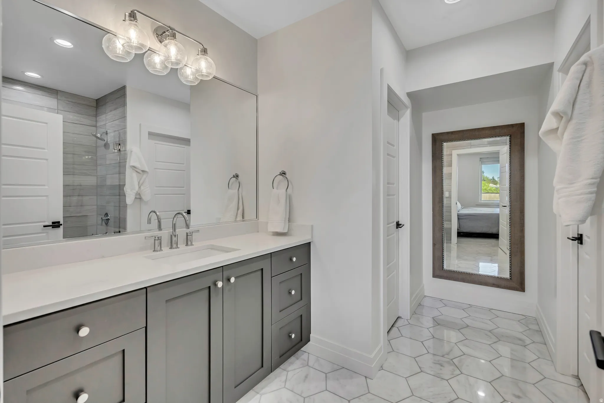Full bathroom featuring vanity, ensuite bathroom, tiled shower, and recessed lighting