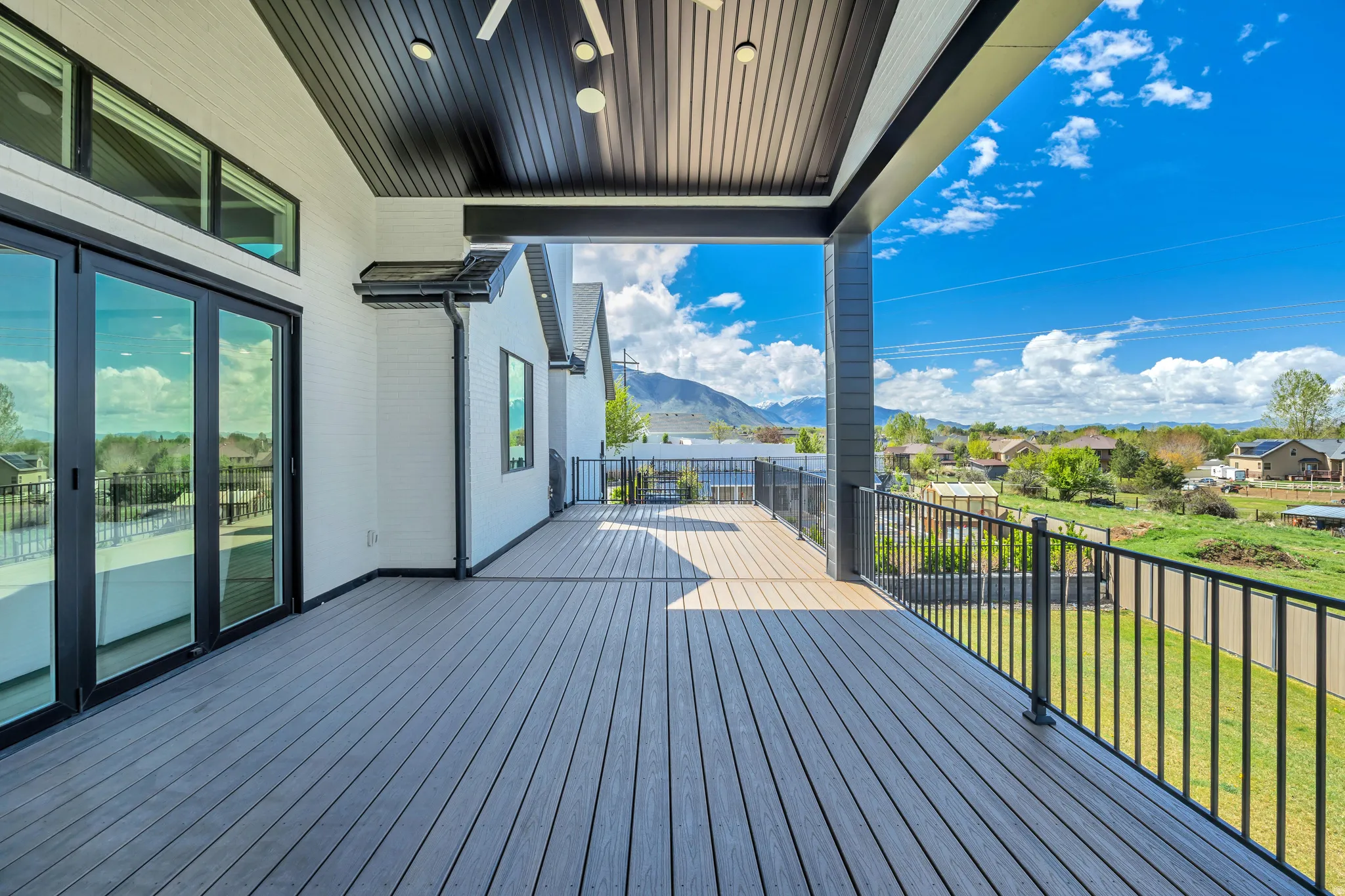Wooden deck with a mountain view, a yard, and a residential view