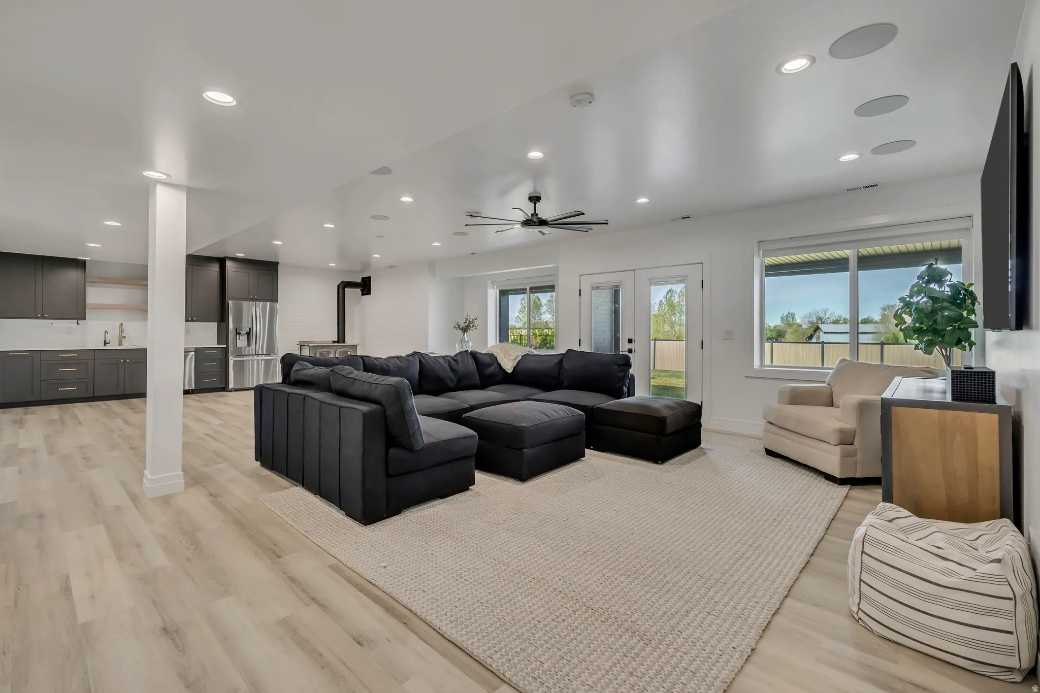 Living area with light wood-type flooring, recessed lighting, ceiling fan, and french doors