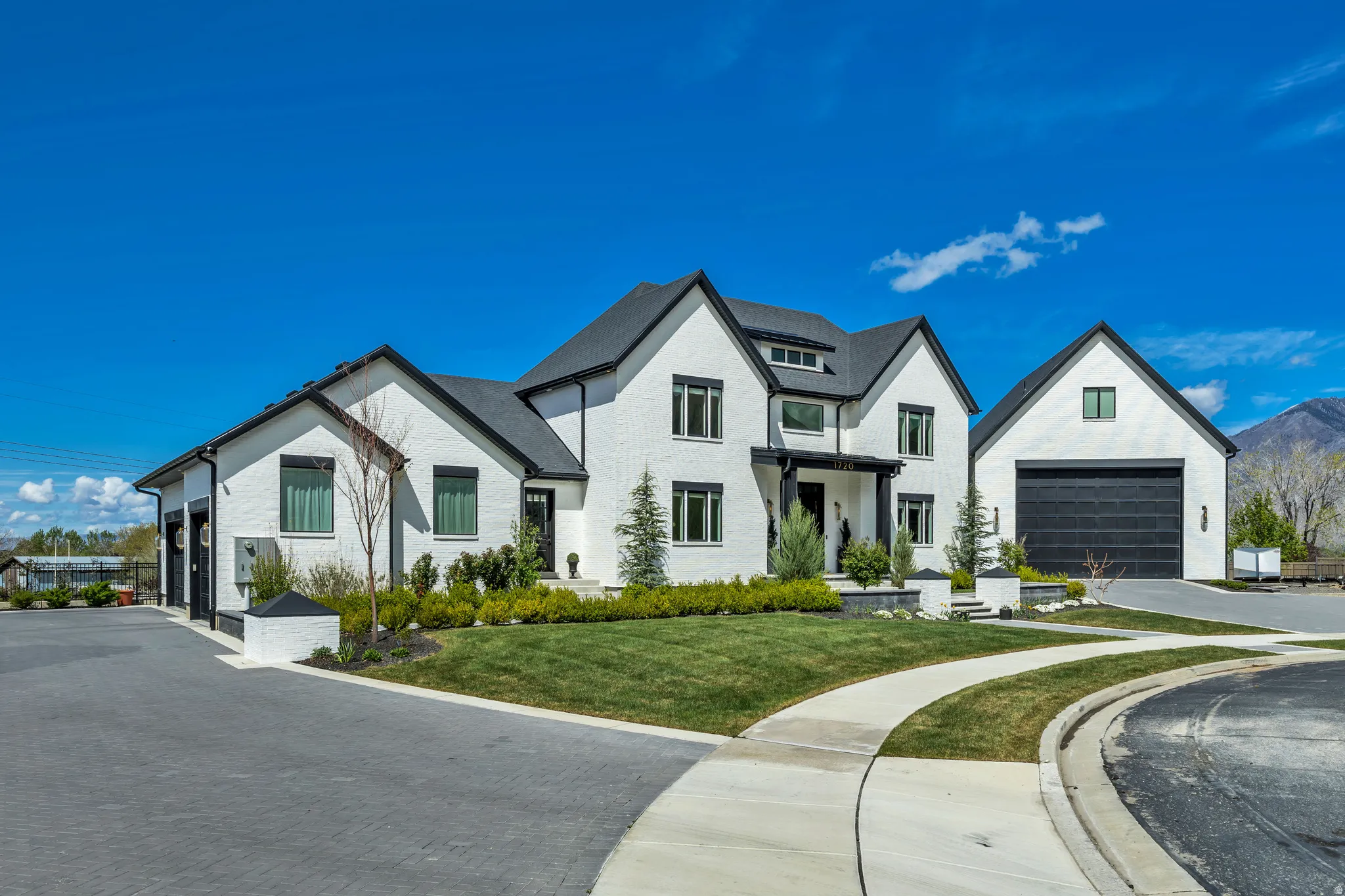 Modern farmhouse style home featuring a front lawn, a garage, and brick siding