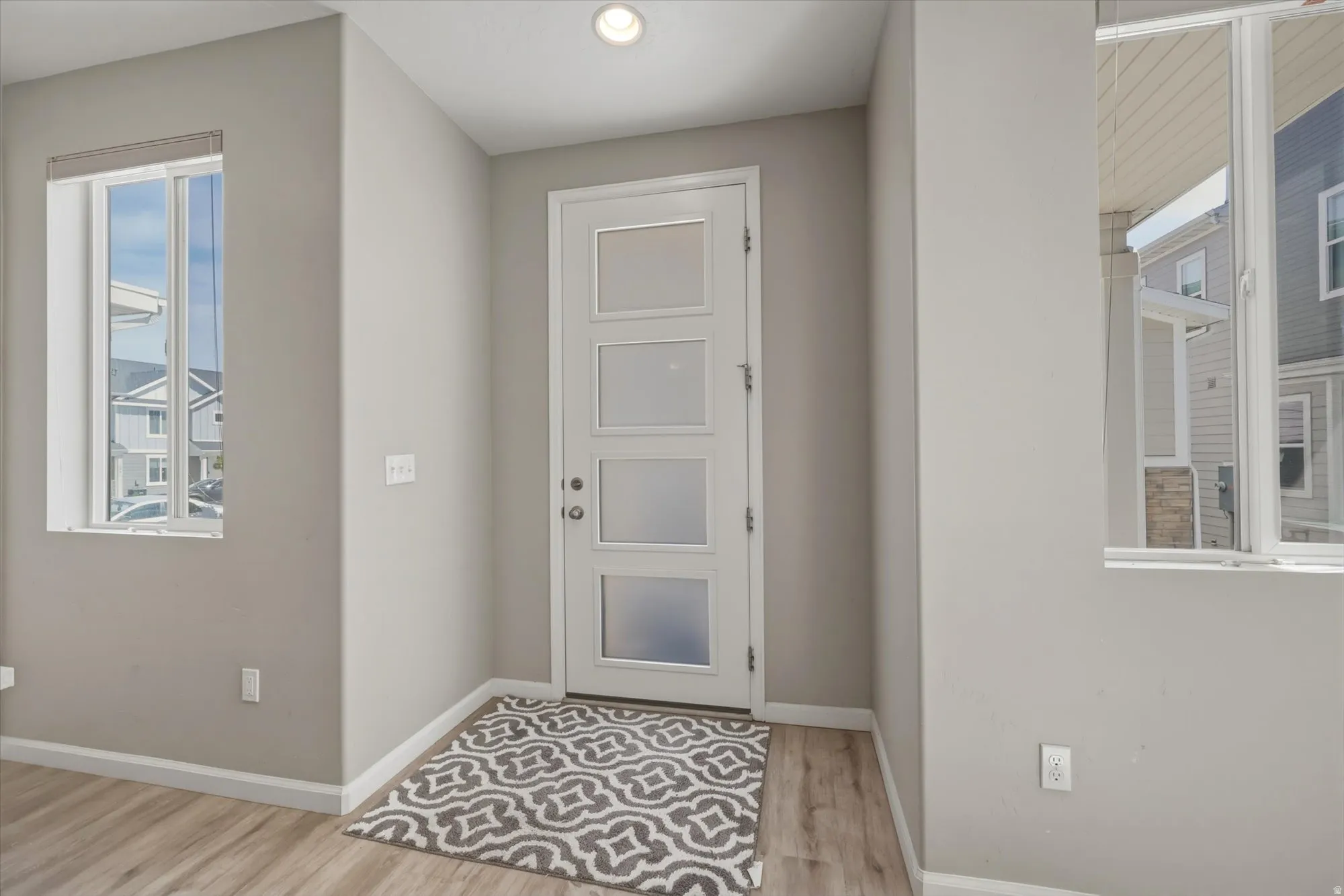 Foyer with baseboards and light wood-style floors