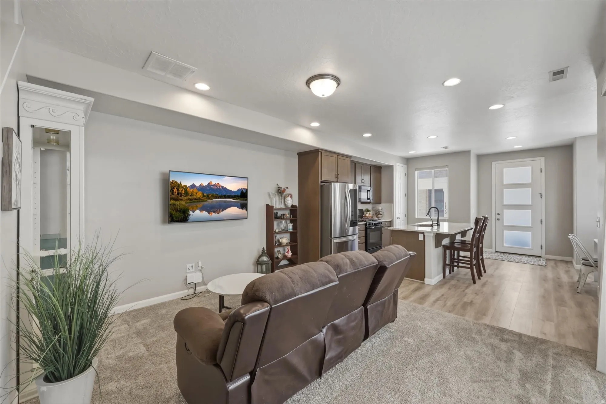 Living area with light colored carpet and recessed lighting