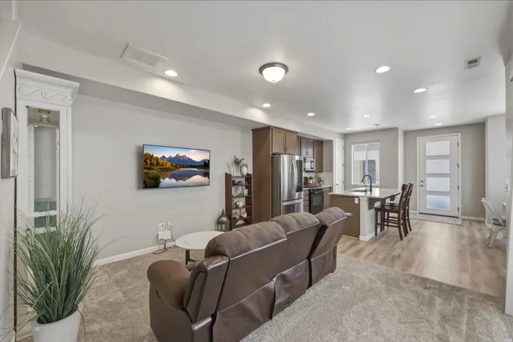 Living area with light colored carpet and recessed lighting