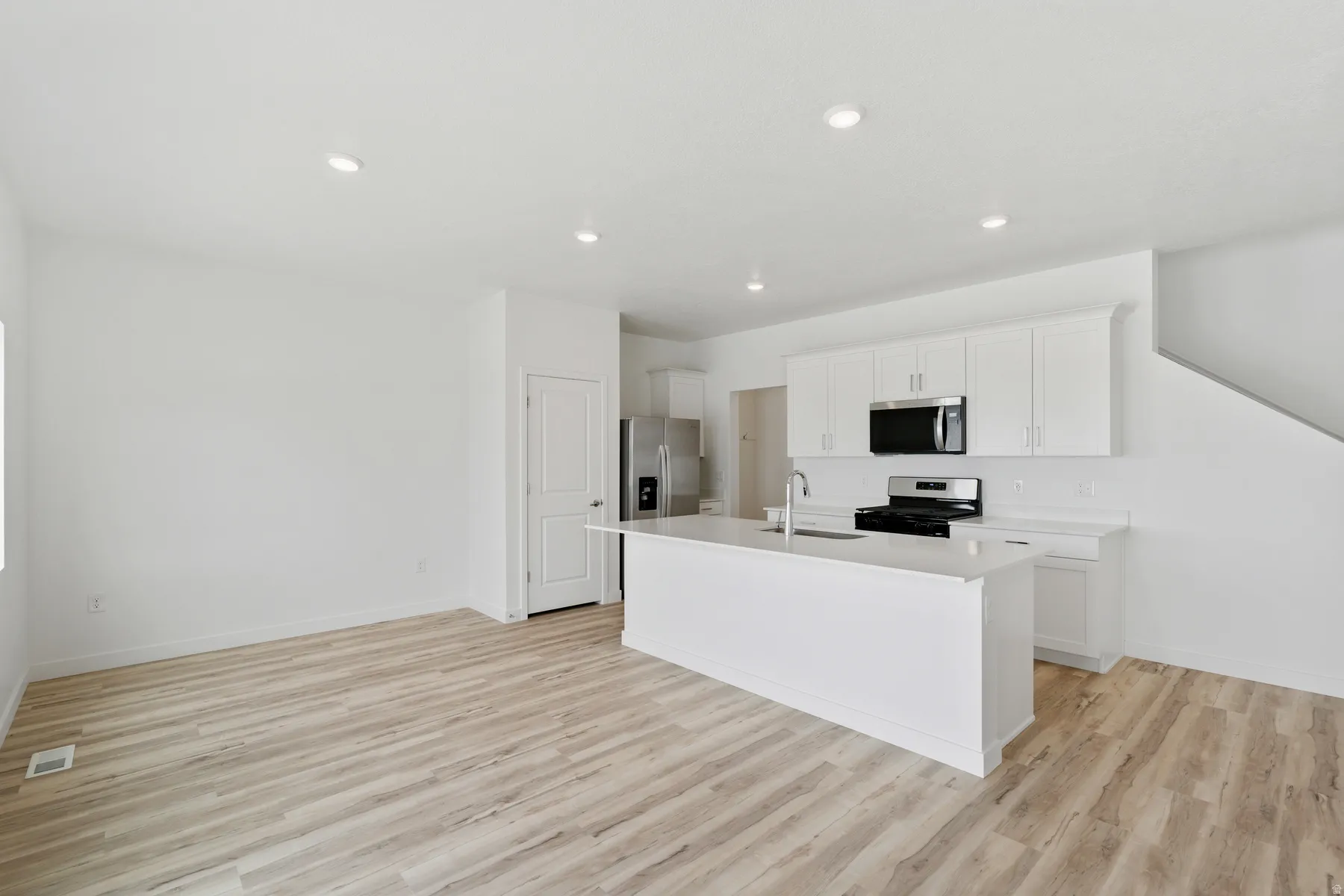Modern kitchen featuring white cabinetry and stainless steel appliances