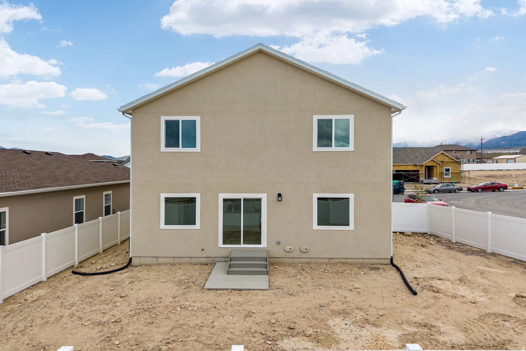 Stucco exterior featuring multiple windows and a sliding glass door