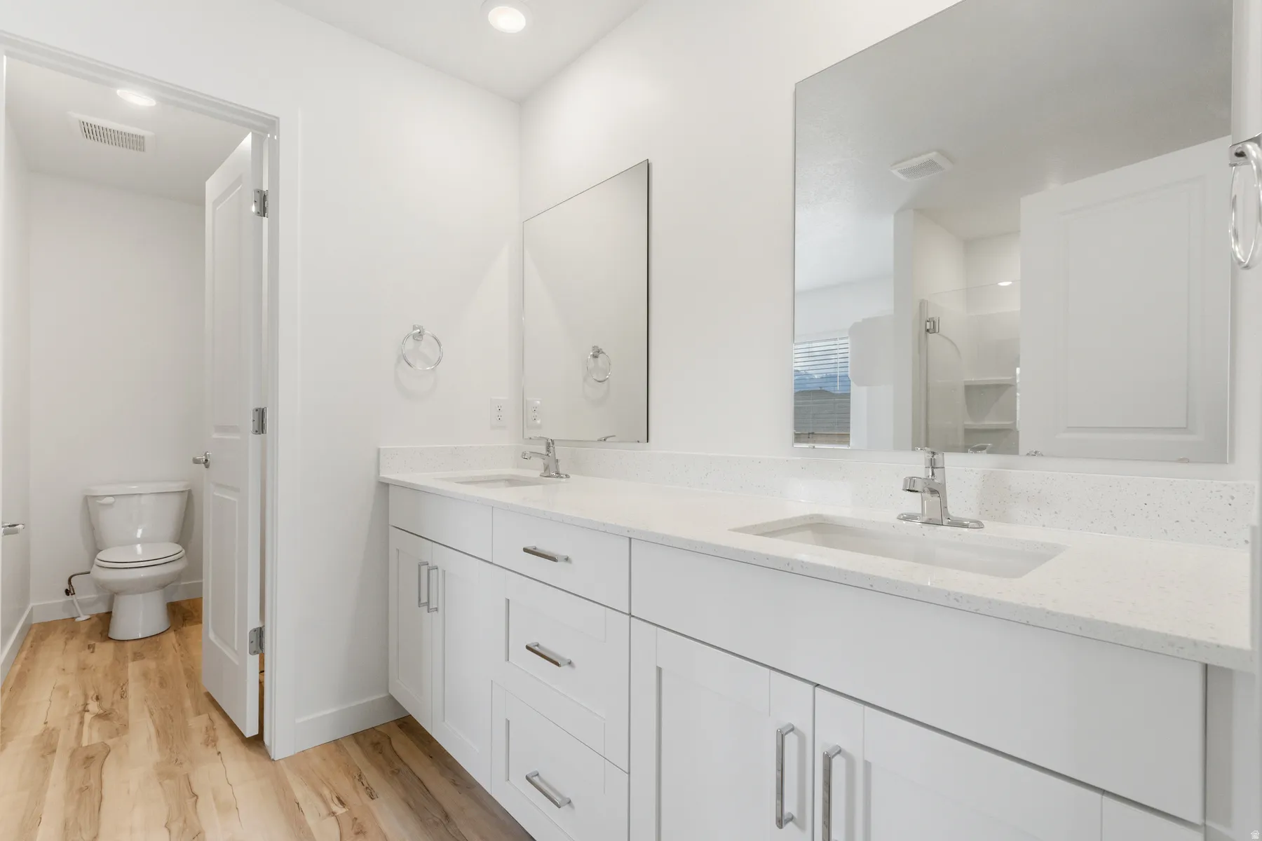 Double vanity featuring white cabinetry with brushed nickel hardware, white quartz countertops, and undermount sinks